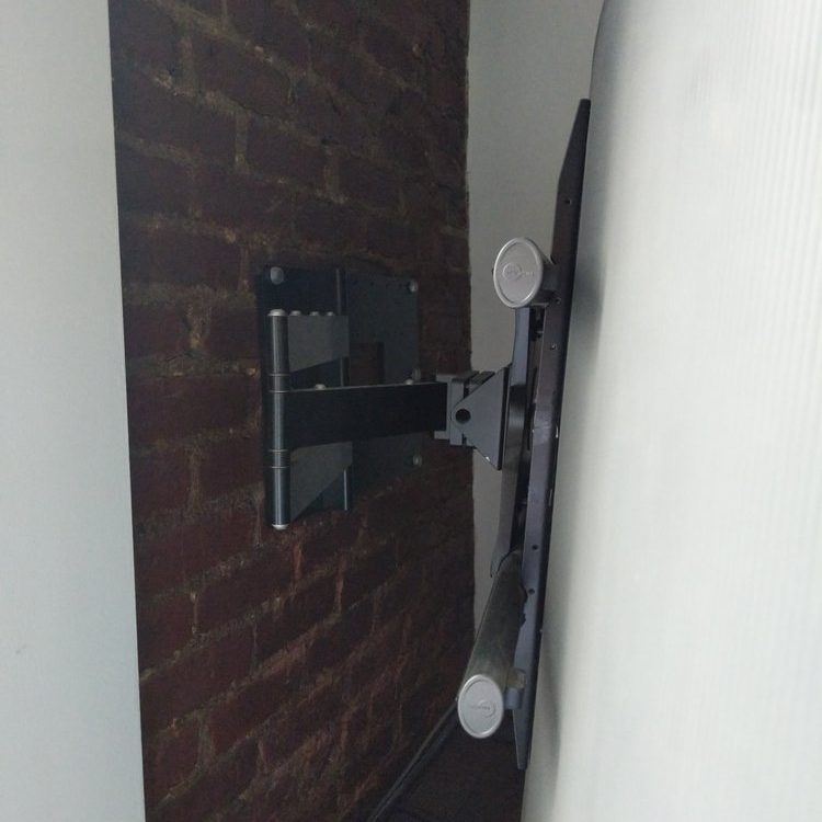 Full motion arm tv mounted on a brick wall