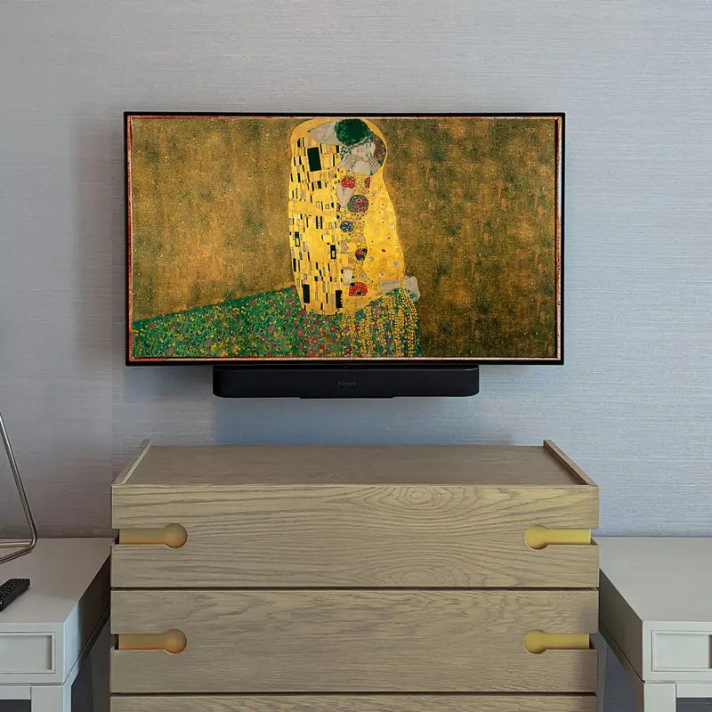 Frame TV showing Klimt's The Kiss above an oak dresser, no wires in sight